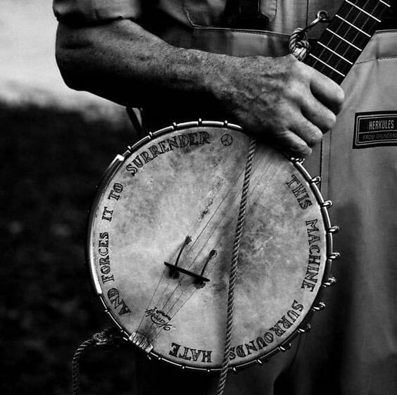 Pete Seeger's banjo with hand lettering that reads: This machine surrounds hate and forces it to surrender.